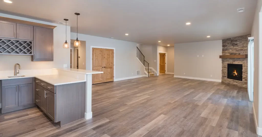 Spacious basement remodeling design with custom bar area, fireplace feature wall, and open-concept layout